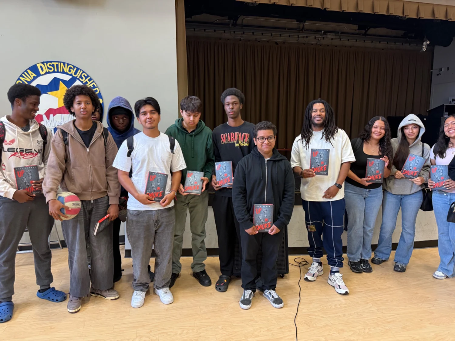 Nick Brooks with students holding copies of Up in Smoke