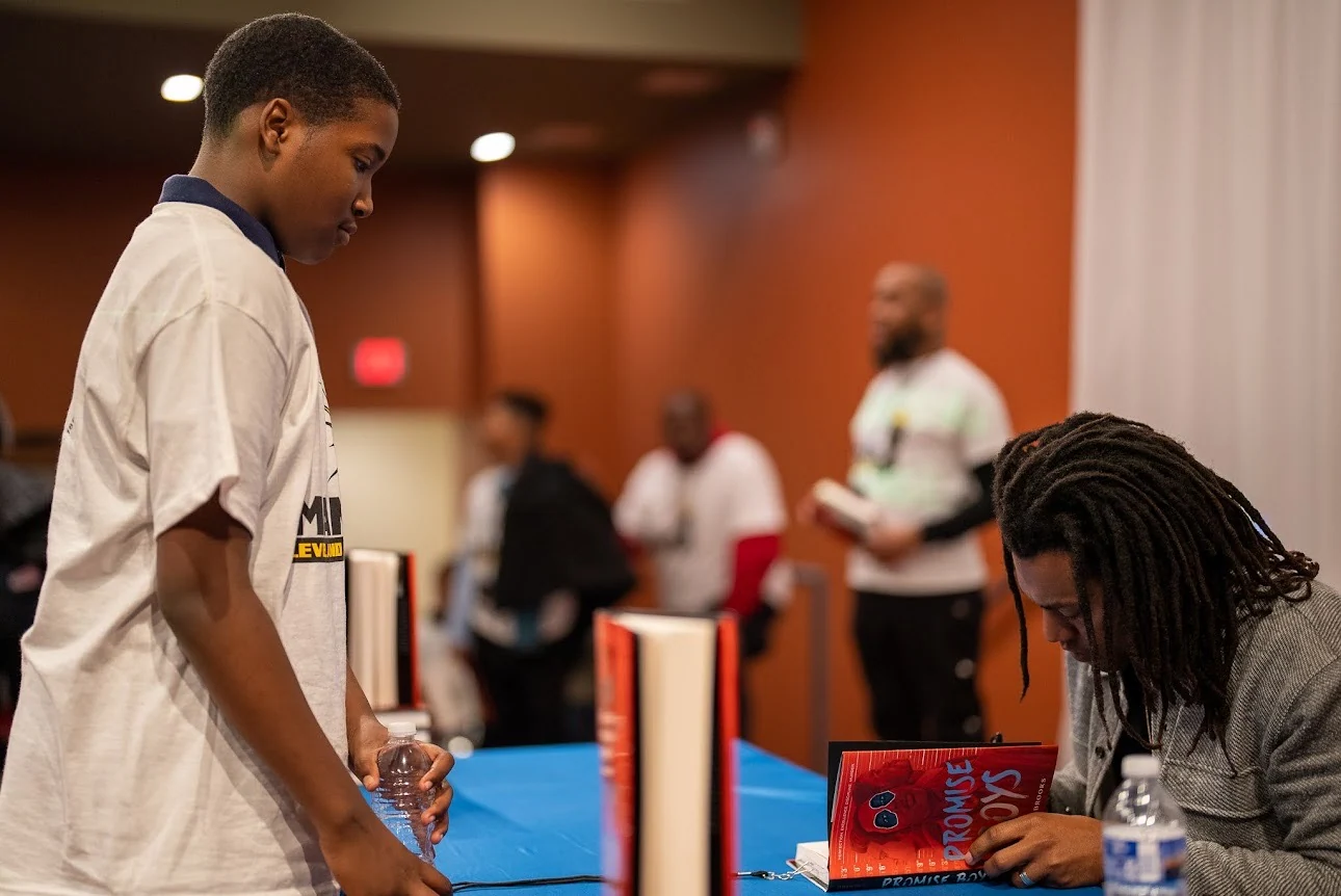 Nick Brooks signing a book for a student